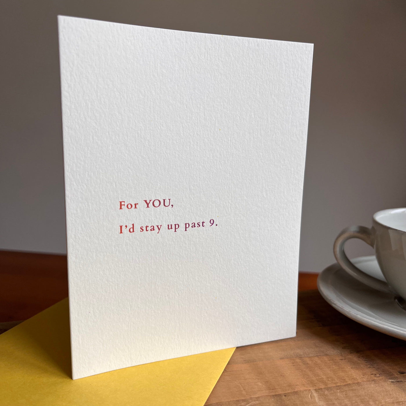 Beknown greeting card next to coffee cup. For you, I'd stay up past 9.