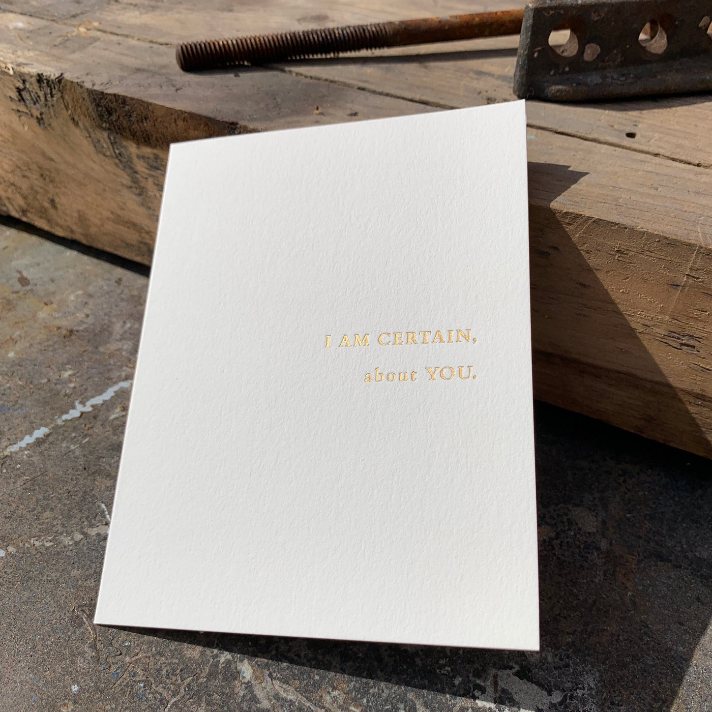 Greeting card on wood table by beknown. I am certain, about you.
