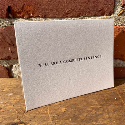 Greeting card on wood table by beknown. You. Are a complete sentence.